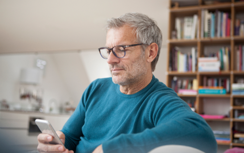 Homme sur un canapé tenant un smartphone